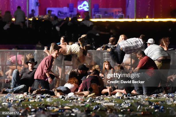 People scramble for shelter at the Route 91 Harvest country music festival after apparent gun fire was heard on October 1, 2017 in Las Vegas, Nevada....