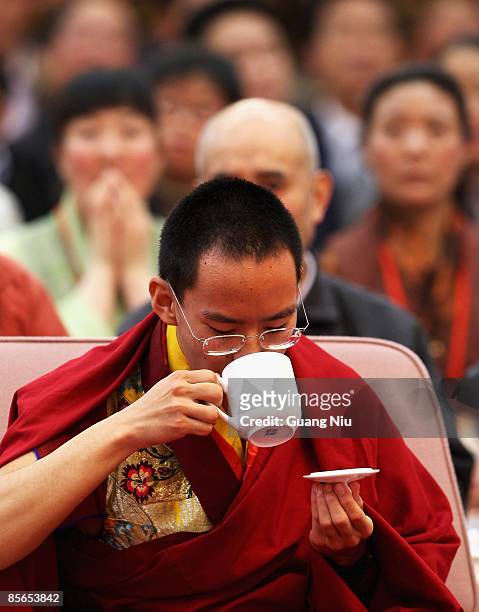 The Panchen Lama, Gyaltsen Norbu, drinks a cup of tea as he attends a government symposium to mark the 50th anniversary on the liberation of Tibetan...