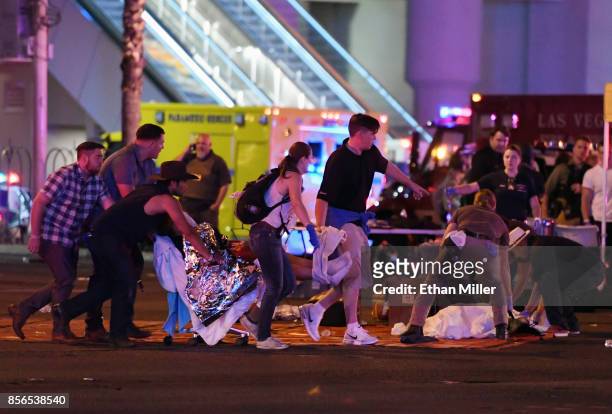 An injured person is tended to in the intersection of Tropicana Ave. And Las Vegas Boulevard after a mass shooting at a country music festival nearby...
