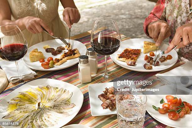 couple at table with assorted tapas - tapas imagens e fotografias de stock