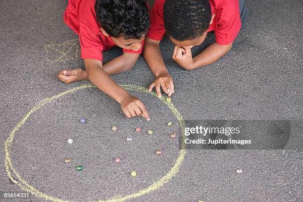 boys playing marbles - murmel stock-fotos und bilder