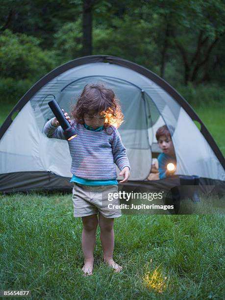 girl looking at grass with flashlight - barefoot child stock pictures, royalty-free photos & images