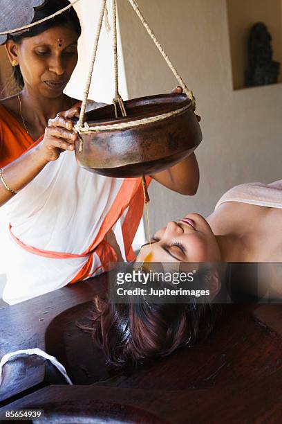 woman receiving shirodhara therapy - shirodhara stock pictures, royalty-free photos & images
