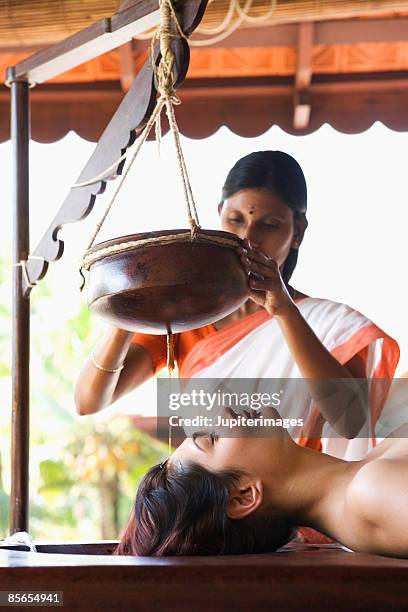 woman receiving shirodhara therapy - shirodhara stock pictures, royalty-free photos & images