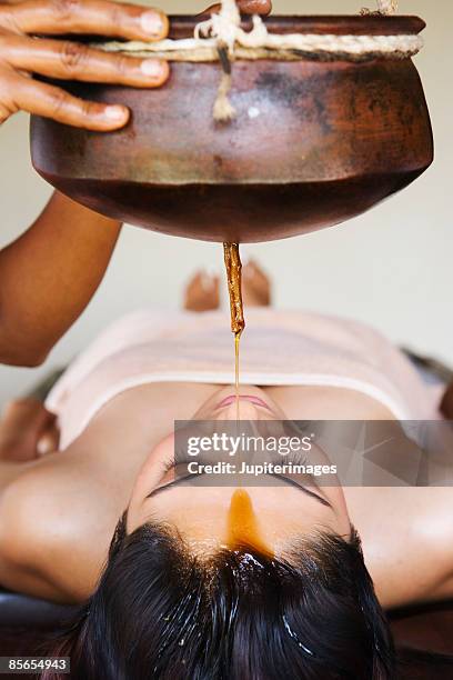 woman receiving shirodhara therapy - shirodhara stock pictures, royalty-free photos & images