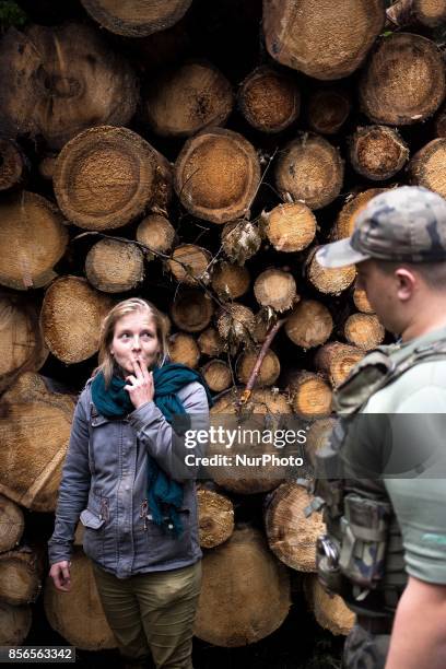 Activist woman smokes a cigarette during talk with Forest Ranger after blockade of Harvester. Bialowieski forest on September 22, 2017.