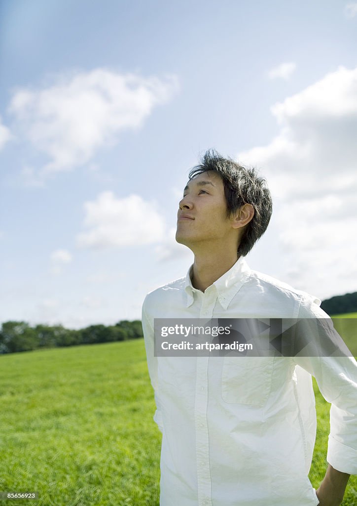 Young man looking up blue sky