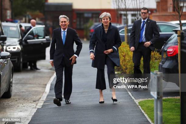 British Prime Minister Theresa May and Chancellor of the Exchequer Philip Hammond leave after visiting a home in Walkden, near the Conservative...