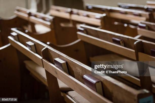 christian hymnbooks on pew / bench inside church - libro-de-himnos fotografías e imágenes de stock