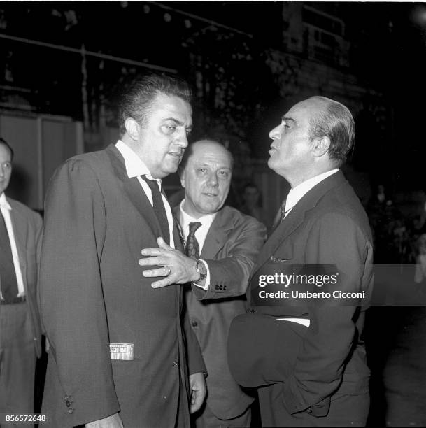 Italian film director Federico Fellini at the cocktail party for the movie 'La Dolce Vita' with film producers Franco Magli and Giuseppe Amato,...