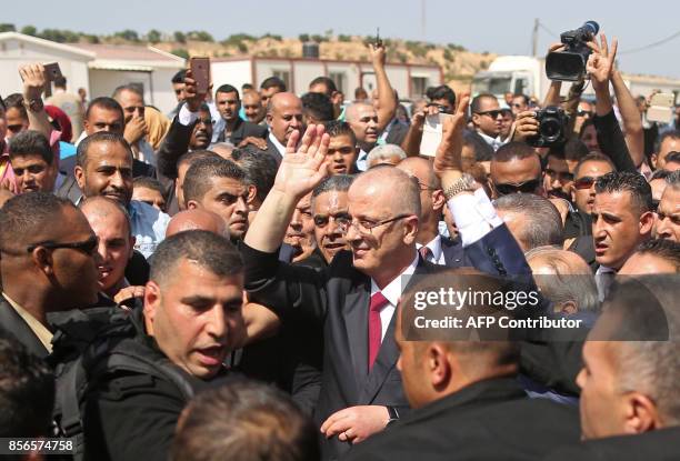 Palestinian prime minister Rami Hamdallah is surrounded by security as he waves following his arrival at the Erez border crossing in Beit Hanun in...