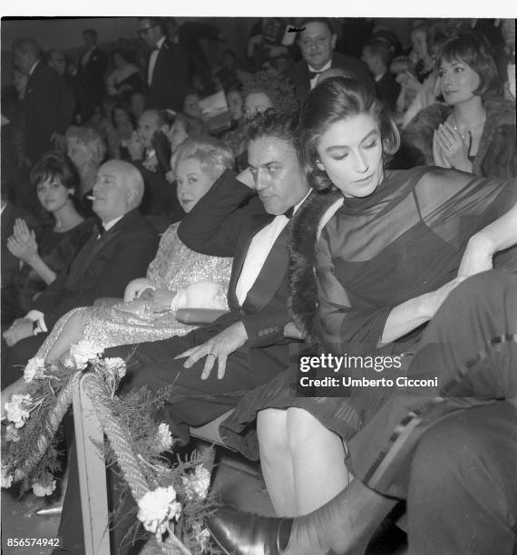 Italian film director Federico Fellini at the 'Cinema Fiamma' in Rome with Angelo Rizzoli , Giulietta Masina and Anouk Aimee.