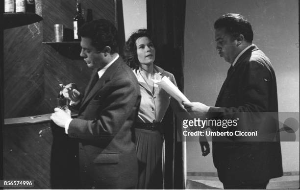 Italian film director Federico Fellini is reading a script while he is with the actress Lea Massari and the actor Marcello Mastroianni, Rome 1959.