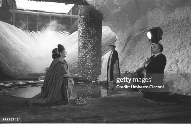 Federico Fellini on set with two actors while directing the movie 'Satyricon' in 1969.