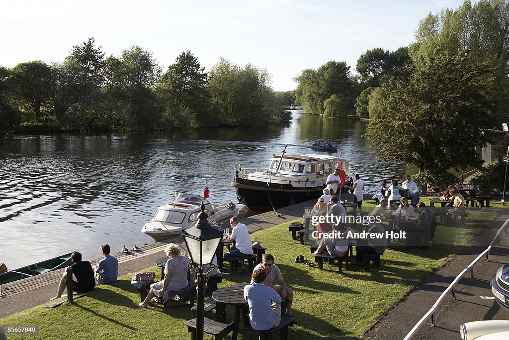 People in pub garden by River Thames in summer