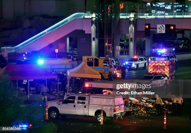 Police and rescue personnel gather at the intersection of Las Vegas Boulevard and Tropicana Ave. After a mass shooting at a country music festival...