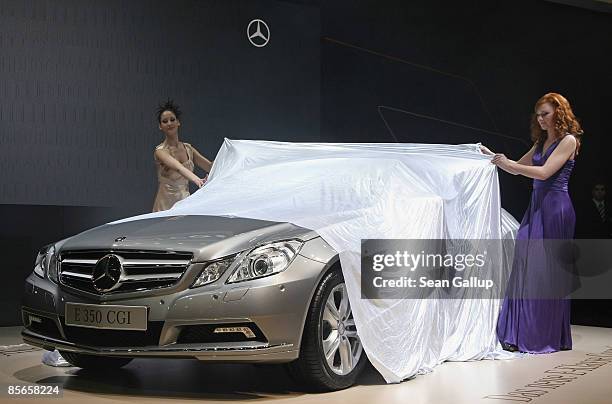 Models unveil the new E-Class Coupe at the stand of German automaker Mercedes-Benz at the AMI 2009 International Auto Fair press day on March 27,...