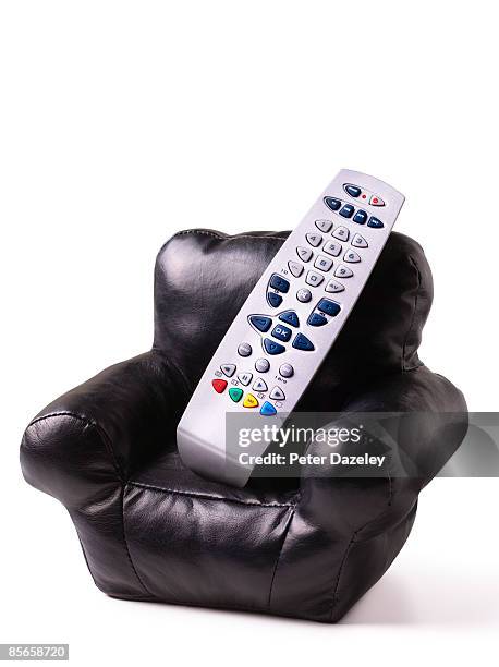 remote control in leather arm chair.  - couch potato stock pictures, royalty-free photos & images