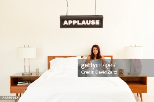 Woman in bed with "Applause" sign over it. Woman in bed with "Applause" sign over it.
