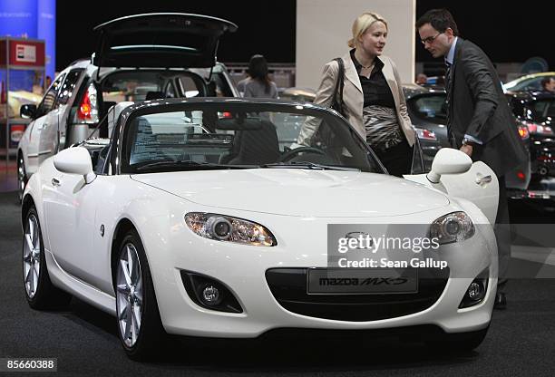 Visitors check out an MX-5 convertible car at the stand of Japanese automaker Mazda at the AMI 2009 International Auto Fair press day on March 27,...