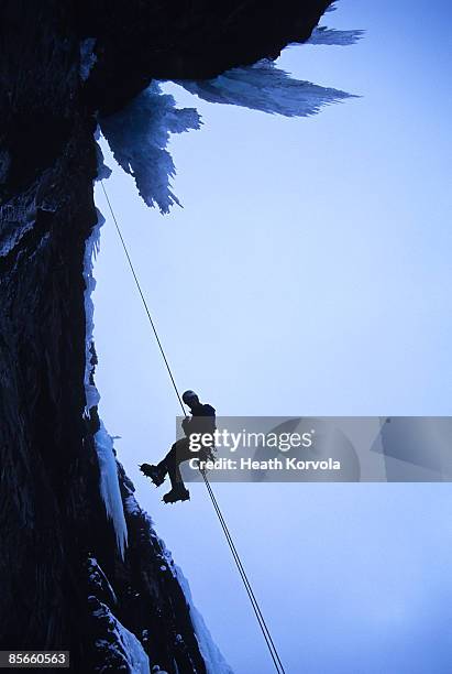 man rappelling off ice climb. - rappelling stock pictures, royalty-free photos & images