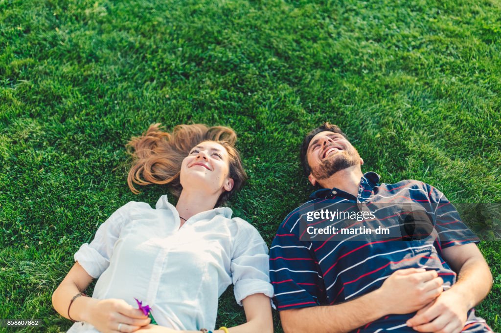 Happy couple in the grass dreaming