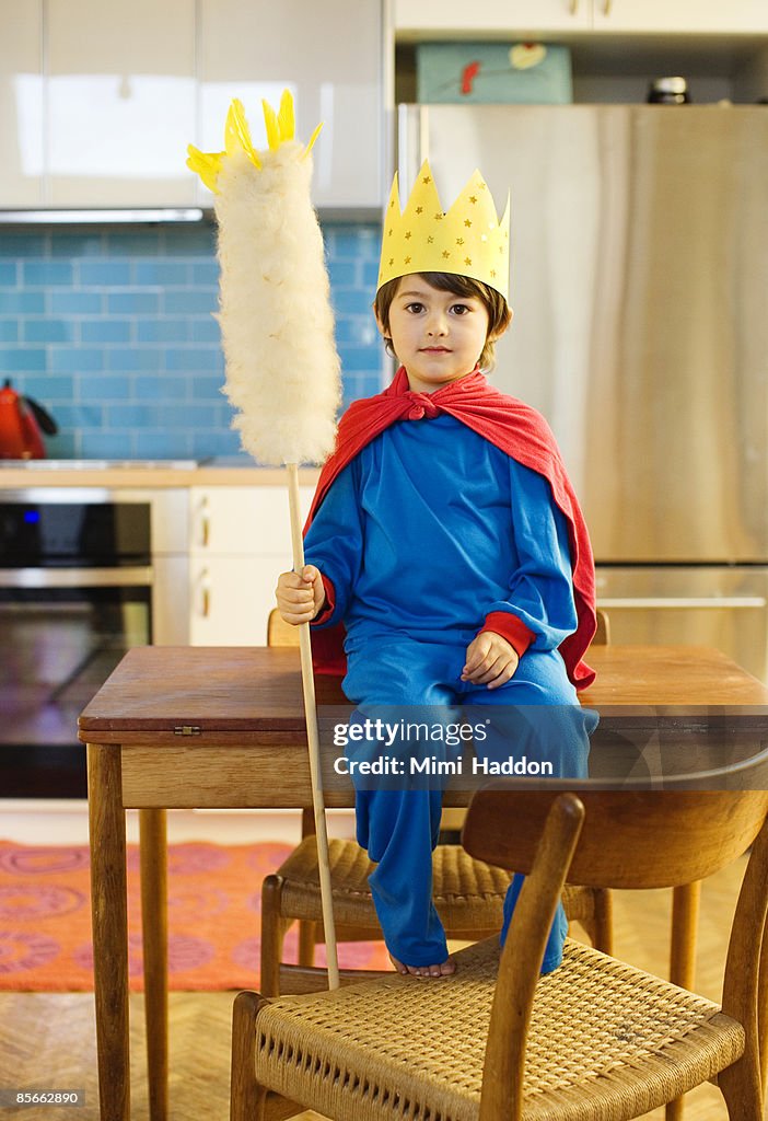 Boy dressed as king in his kitchen