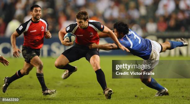 Van der Merve of Canada moves the ball up against Alafoti Fa'osiliva of Samoa during the Day 1 of the IRB Hong Kong Sevens on March 27, 2009 in Hong...