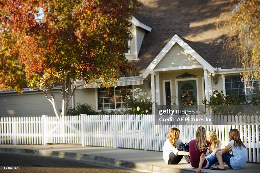 Four friends sit on suburban cul de sac