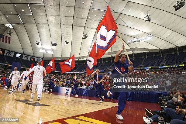 Cheerleaders for the Dayton Flyers runs by players from the Kansas Jayhawks during warm ups for their second round of the NCAA Division I Men's...