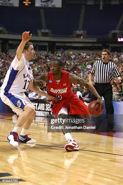 Mickey Perry of the Dayton Flyers drives against Brady Monringstar of the Kansas Jayhawks during the second round of the NCAA Division I Men's...