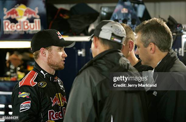 Brian Vickers, driver of the Red Bull Toyota, talks with members of his team in the garage area during practice for the NASCAR Sprint Cup Series...