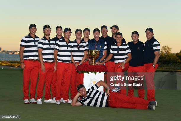 Team poses with the President's Cup Trophy during the Sunday singles matches at the Presidents Cup at Liberty National Golf Club on October 1 in...