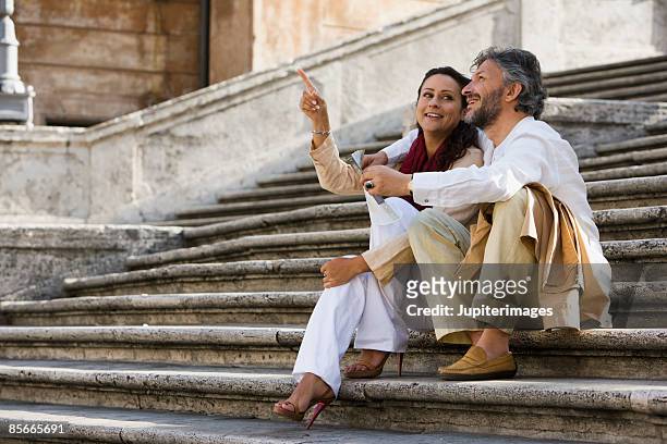 couple sitting on stone steps - rome italy stock-fotos und bilder
