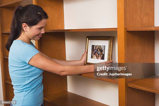 Putting Something In 356 Woman Putting Something On Shelf Stock Photos, High-Res Pictures ...