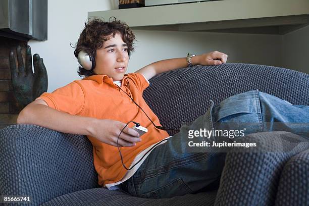boy listening to music on headphones - boy ipod stock pictures, royalty-free photos & images