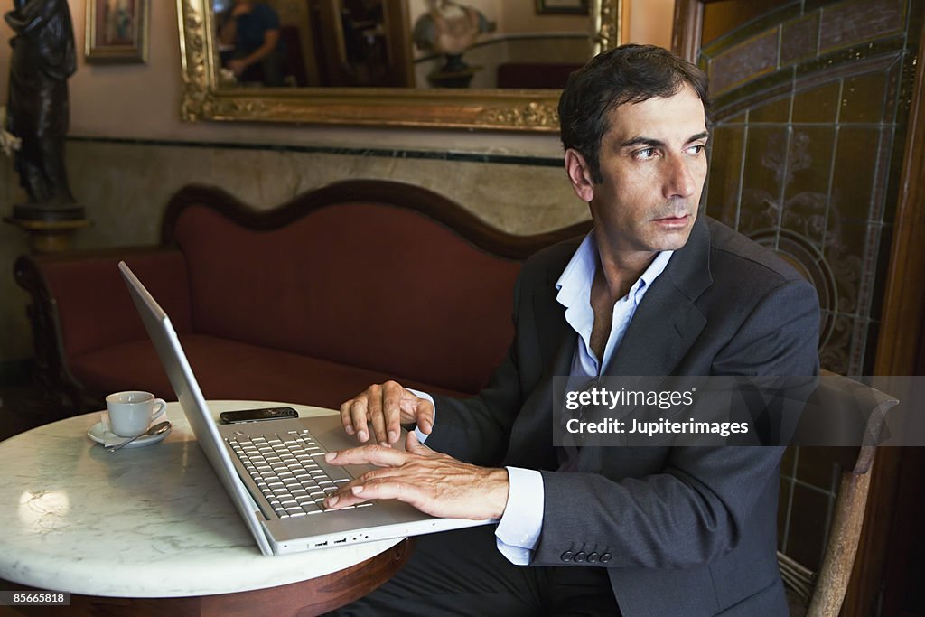 Man working on laptop computer in cafe