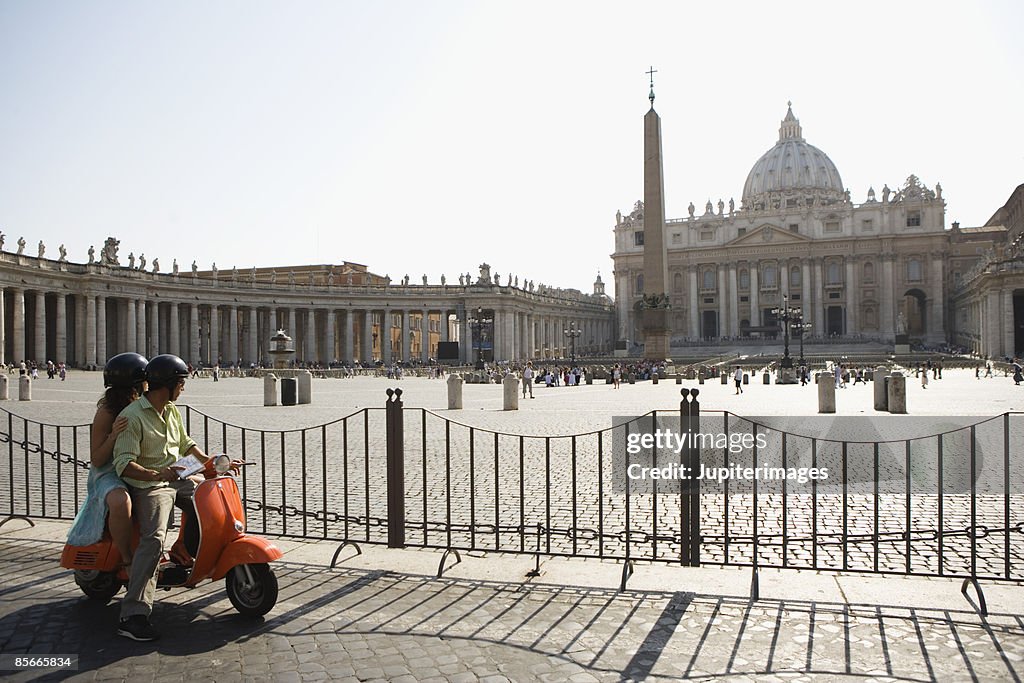 Couple on motor scooter , Saint Peter's Cathedral , Vatican City , Rome , Italy