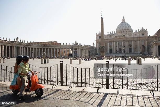 couple on motor scooter , saint peter's cathedral , vatican city , rome , italy - basílica de são pedro - fotografias e filmes do acervo
