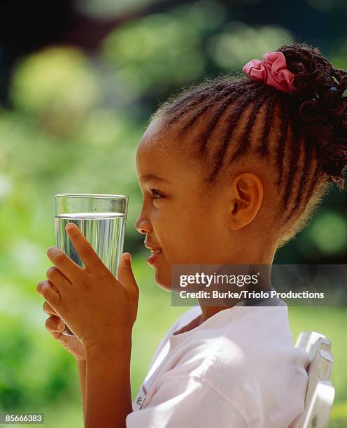 girl with water glass - african girl drinking water stock-fotos und bilder
