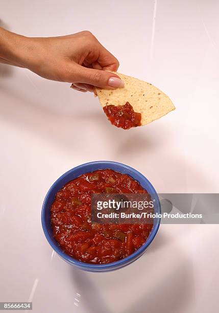 hand with chip and salsa - salsa stock-fotos und bilder