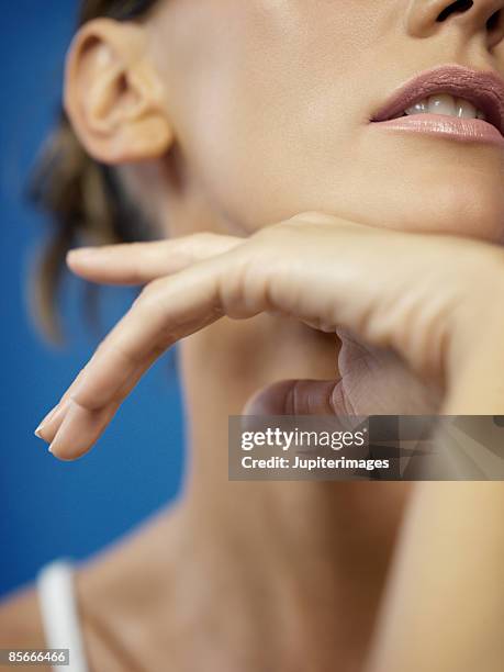 close-up of woman resting chin on back of hand - hand on chin stock-fotos und bilder