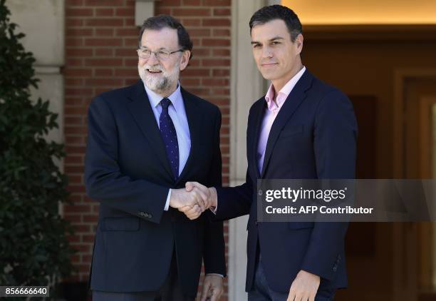 Spanish Prime Minister Mariano Rajoy shakes hands with Spanish Socialist Party PSOE leader Pedro Sanchez prior to holding a meeting at La Moncloa...