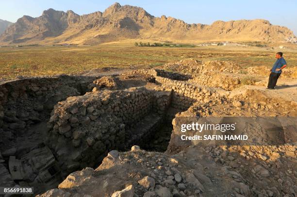 Picture taken on October 1, 2017 shows a man inspecting a historical site at the ancient city of Qalatga Darband, which is believed to have been...