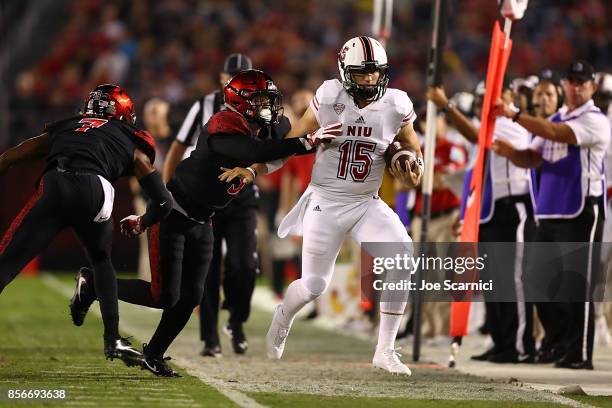 Marcus Childers of the Northern Illinois Huskies is pushed out of bounds in the first quarter by Trey Lomax of the San Diego State Aztecs during the...