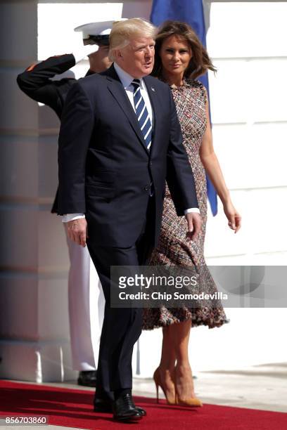 President Donald Trump and first lady Melania Trump walk out of the White House before greeting Prime Minister Prayut Chan-o-cha of Thailand October...
