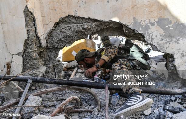 Members of the Syrian Democratic Forces , Syrian fighters backed by US special forces, search newly taken areas near the central hospital of Raqa on...