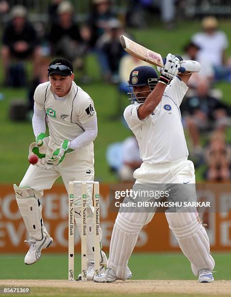 Indian cricketer Sachin Tendulkar plays a shot as New Zealand wicketkeeper Brendon McCullum looks on during the third day of the second Test match at...