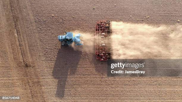 anbau feld traktor munter felsen und staub in der morgendämmerung - dust storm stock-fotos und bilder