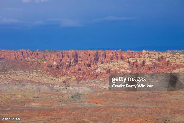 car on road in salt valley, arches np, utah - salt valley arches national park stock pictures, royalty-free photos & images